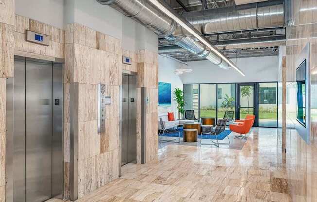 A hallway with wood floors and metal pipes on the ceiling.