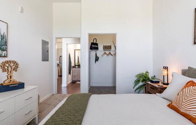 a white bedroom with a bed and a hallway