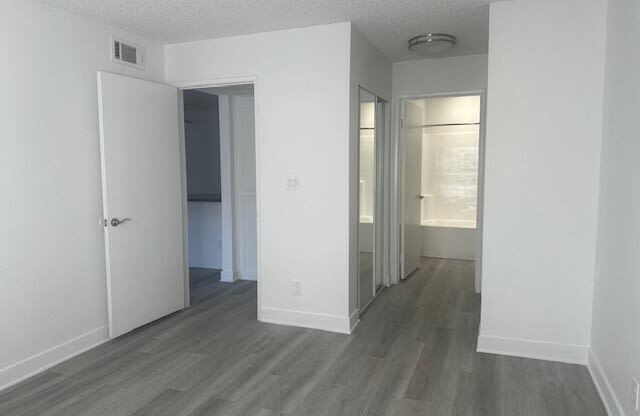 an empty living room with white walls and wood flooring