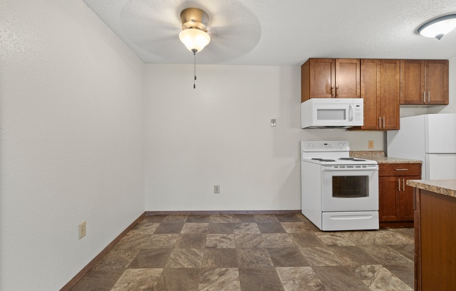 A kitchen with a white oven and microwave.