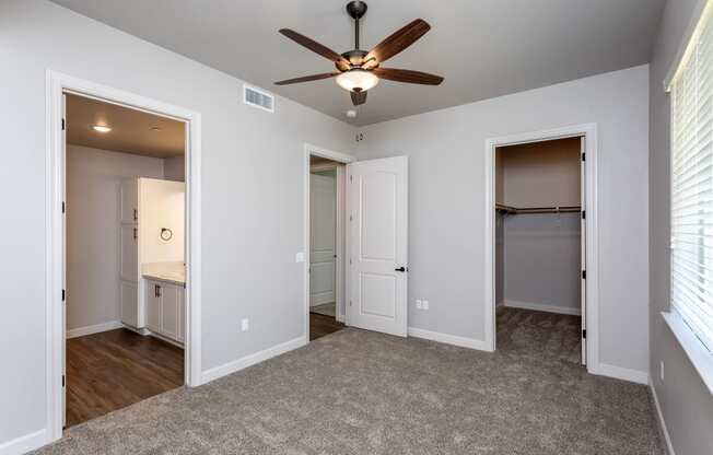 a bedroom with a ceiling fan and two doors