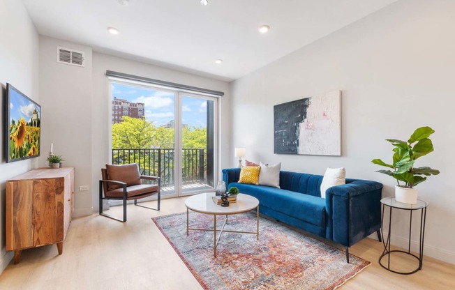 a living room with a blue couch and a sliding glass door