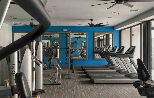 A gym with treadmills, weights, and a fan at Regatta Sloans Lake Apartments, Denver, CO, 80204