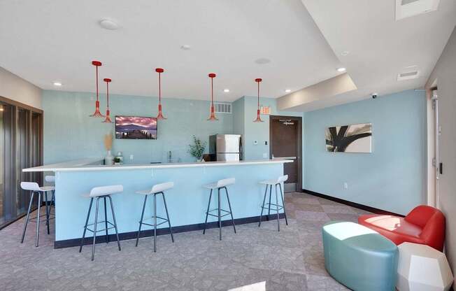 A bar area with white stools and a counter.