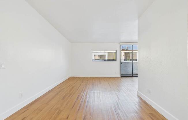 Empty room with wooden floor and white walls.