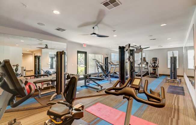 Fitness center with cardio equipment and a ceiling fan