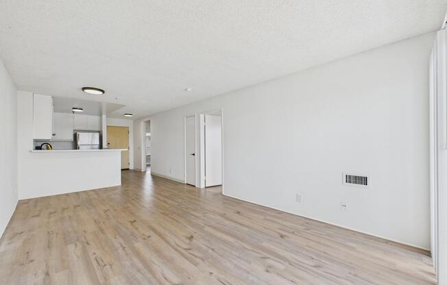A room with wooden flooring and white walls.