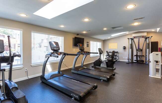 two treadmills and other exercise equipment in the gym of a home