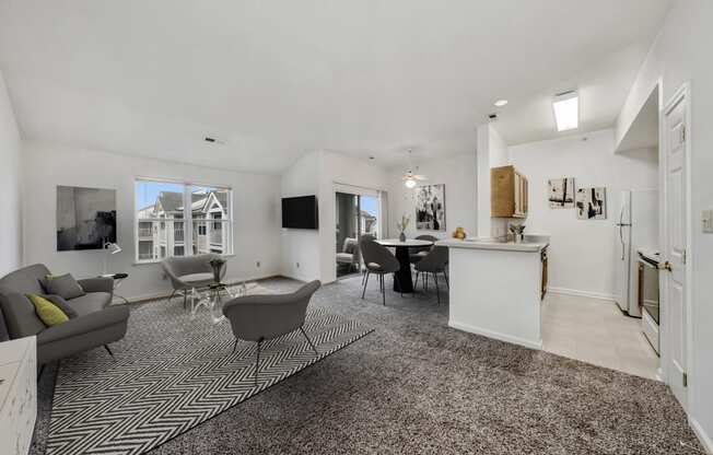 a living room with a kitchen and a table and chairs