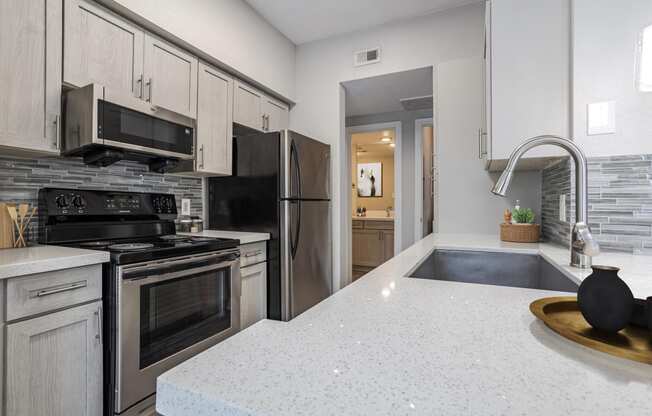 Apartments in Houston, TX for Rent – Gramercy Park -  an updated kitchen with stainless steel appliances and white counter tops