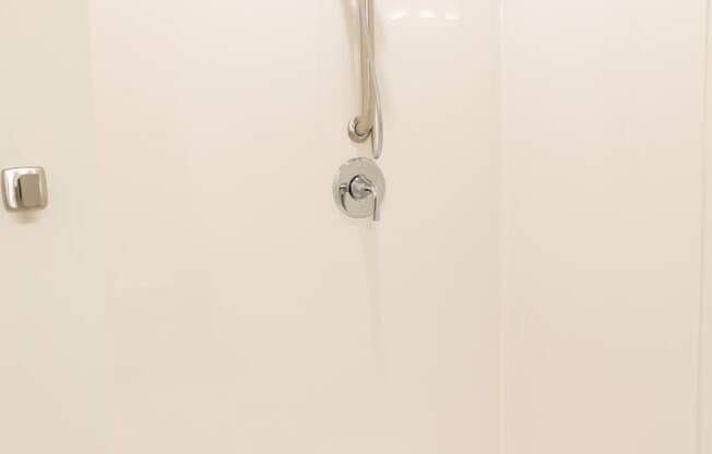 a white shower in a bathroom with a shower curtain