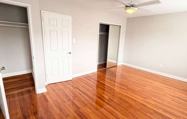A room with a wooden floor and a ceiling fan.