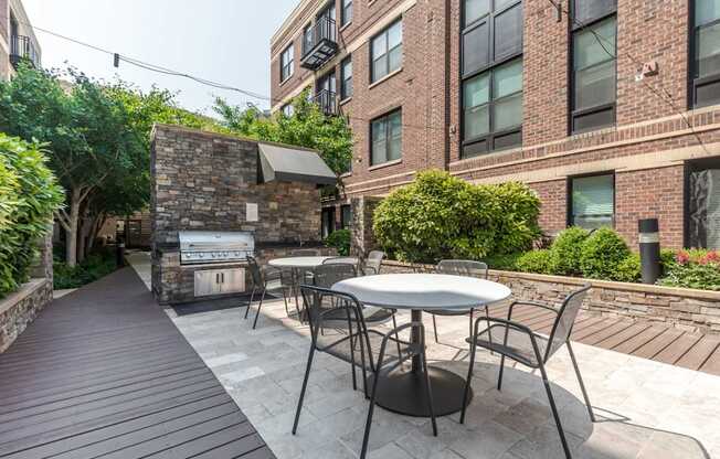 Image showing Outdoor grill station with stainless steel grills and modern seating area.