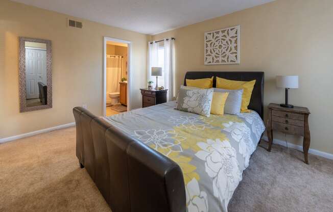 a bedroom with a large bed with yellow pillows and a comforter