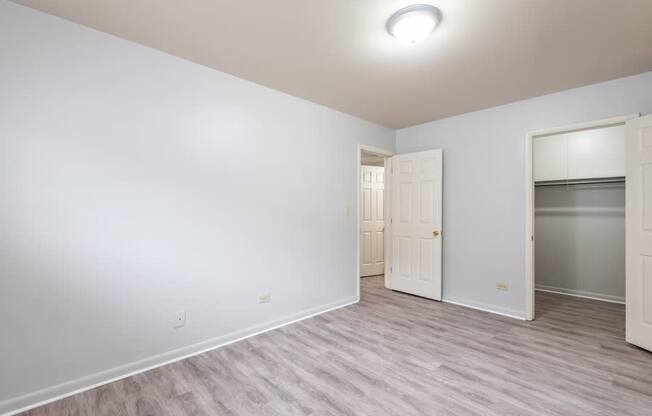 A room with a white door and a grey floor.