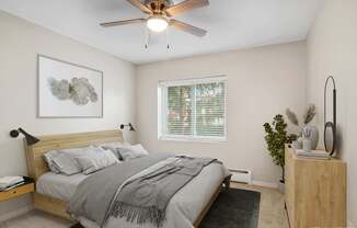 A bedroom with a bed, a ceiling fan, and a nightstand.