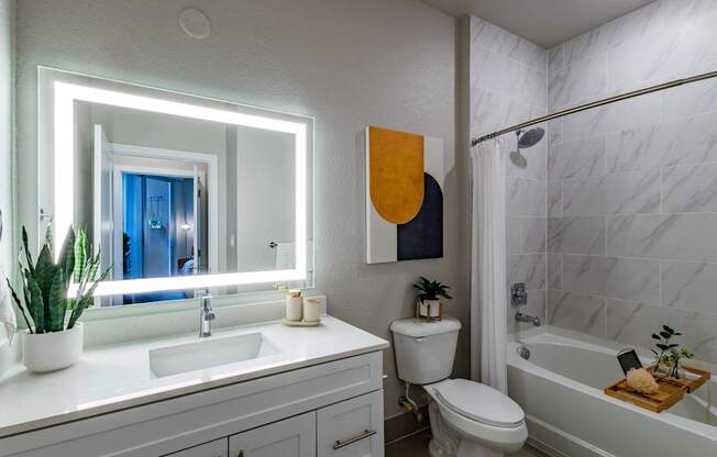 A bathroom with a white sink, toilet, and bathtub.at Icon One, Daytona Beach, Florida