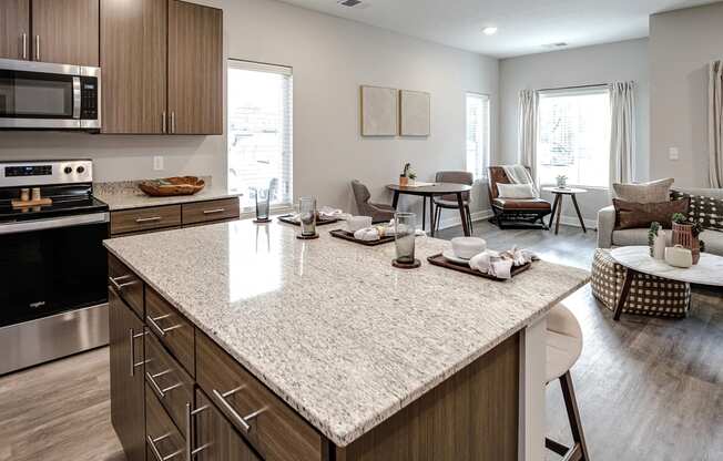 an open kitchen and living room with a large granite counter top