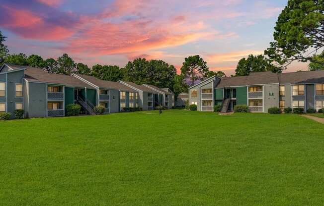 A row of houses with green lawns in front.