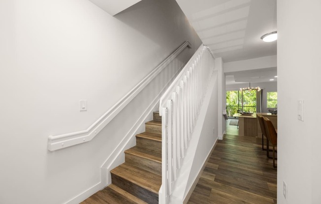 a view of a staircase in a home with white walls and wood floors