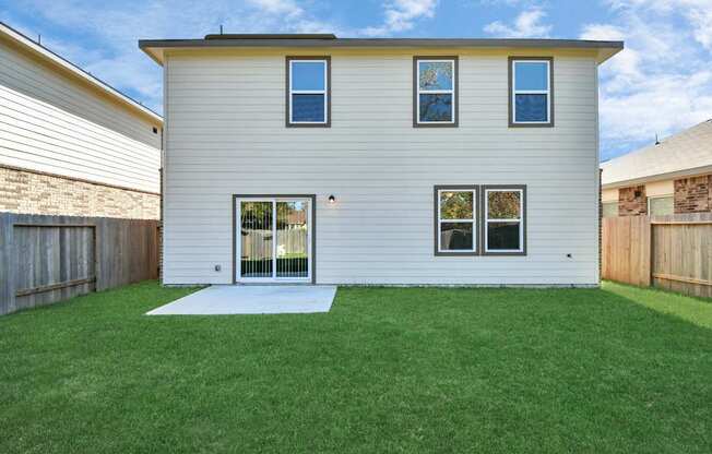 A house with a white exterior and a green lawn.