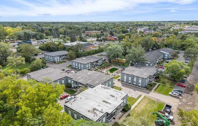 A large industrial building surrounded by trees and other buildings.