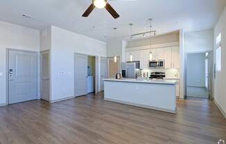 A modern kitchen with a white island and wooden floors.