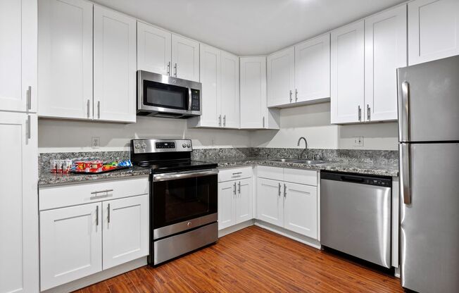 a kitchen with white cabinets and stainless steel appliances