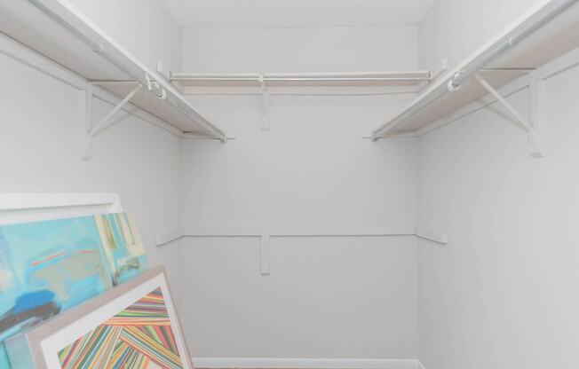 a white room with paintings and white hangers on the wall