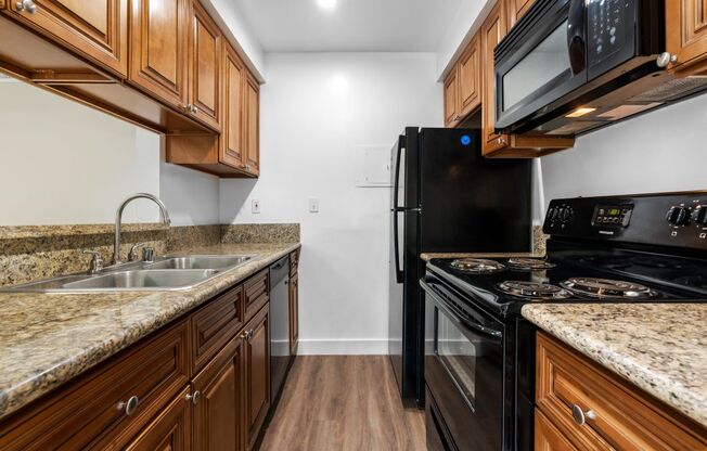 a kitchen with wood cabinets and black appliances