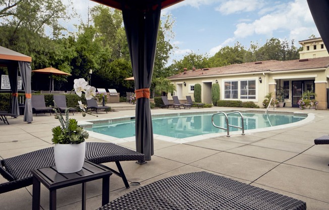 Outdoor pool area with cabanas