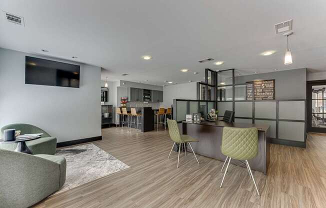 A modern living room with a grey sofa, a green chair, and a wooden floor.