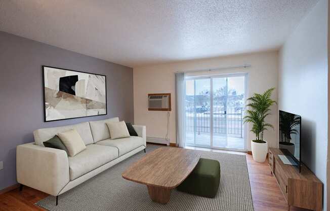 A living room with a white couch and a wooden coffee table. Fargo, ND Park Place Apartments