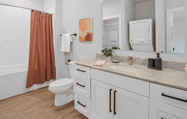 A bathroom with a toilet, sink, and shower.
