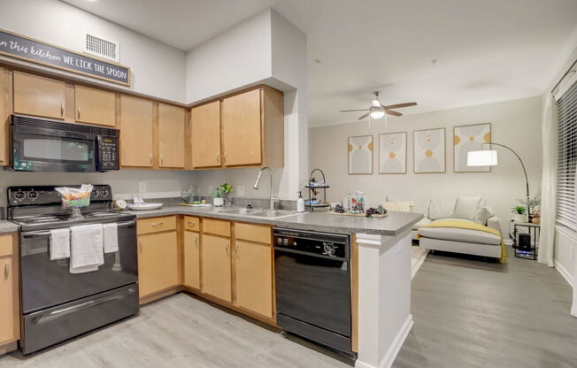A kitchen with wooden cabinets and a black stove top oven.