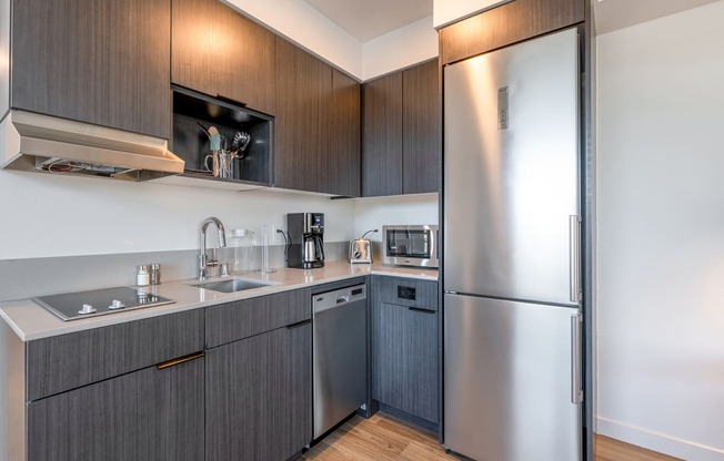 a modern kitchen with dark cabinets and stainless steel appliances at Marina Square, Bremerton, 98337