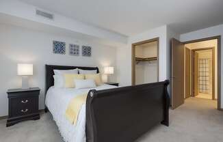 A bedroom with a large bed and a dresser.