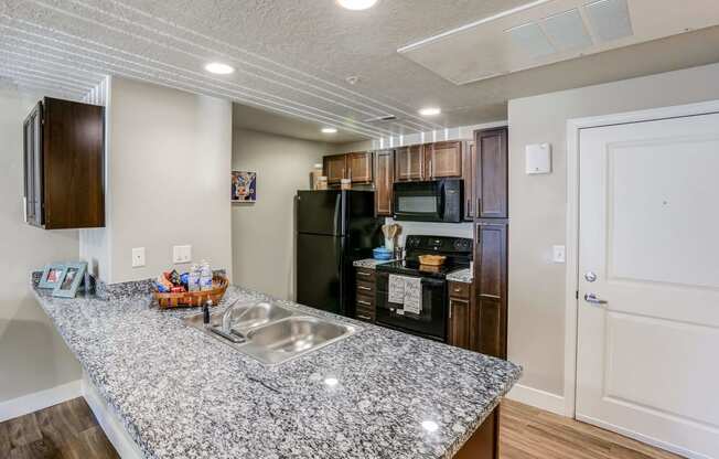 a kitchen with granite countertops and stainless steel appliances at The Beckstead, South Jordan