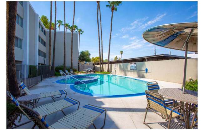 A pool surrounded by palm trees and chairs.