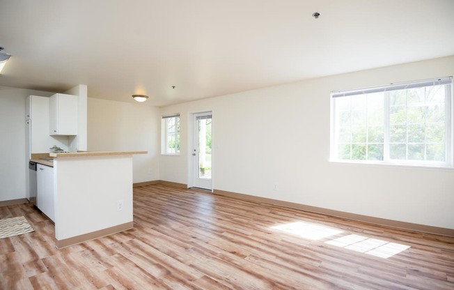 a living room with a kitchen and a hard wood floor