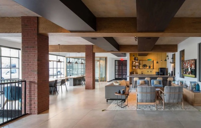 the living room and dining area of a modern house with exposed brick walls