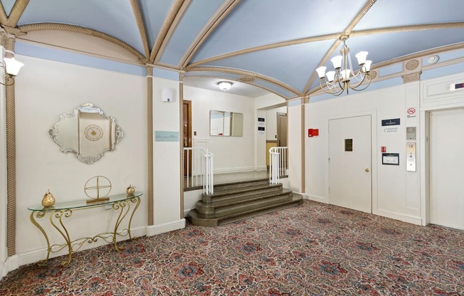 a large lobby area with blue vaulted ceilings with intricate gold detailing and a chandelier at Stockbridge Apartment Homes, Washington, 98101