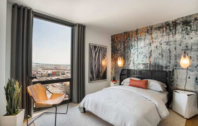 a bedroom with a bed and a window with a city view