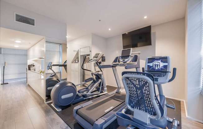 A modern home gym with a treadmill and a stationary bike.