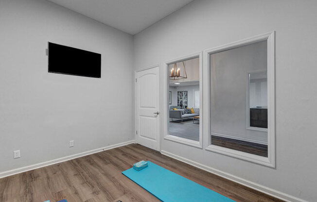 a room with a yoga mat and a tv on the wall