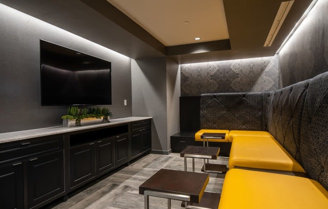 a living room with yellow couches and a television