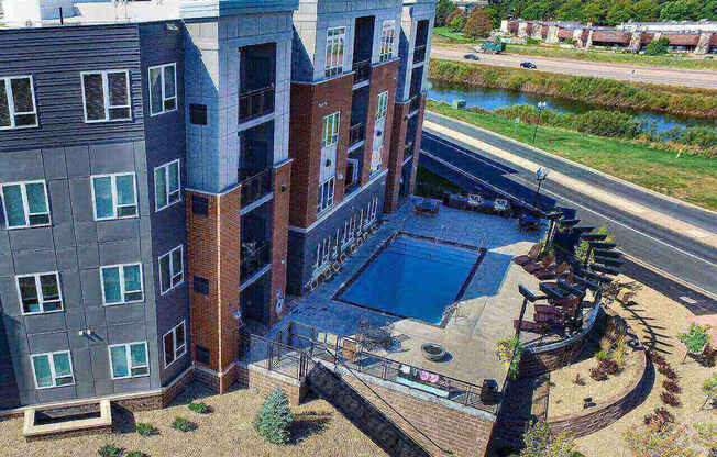 an aerial view of a building with a pool in front of it at The Flats at Cedar Grove, Eagan
