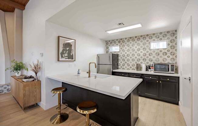 A kitchen with a white countertop and black cabinets.
