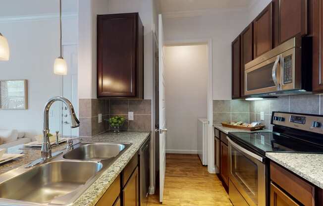 a kitchen with dark wood cabinets and granite countertops