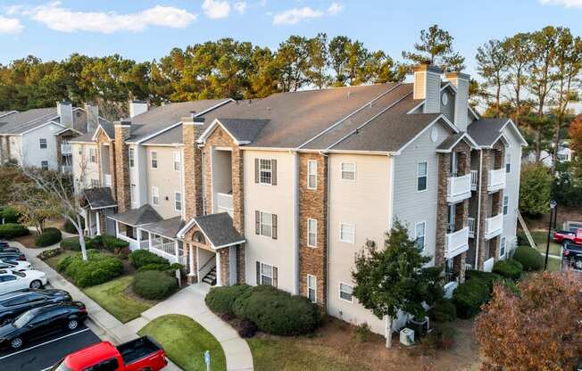 A large apartment complex with a parking lot in front.